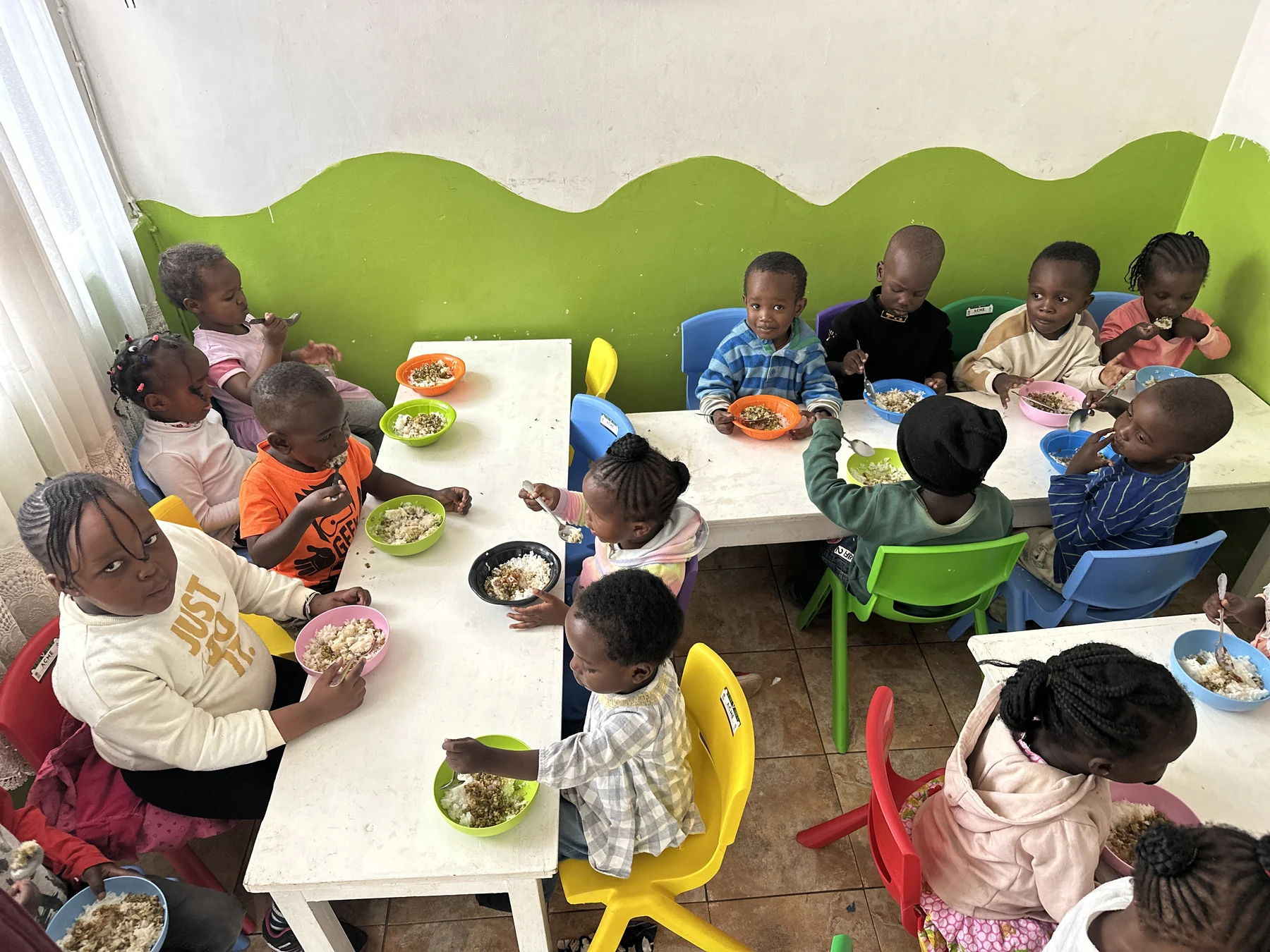 Children gathered around two tables for a meal at Little Heaven